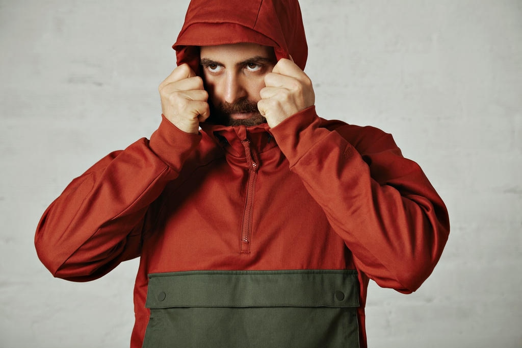 young-bearded-man-covering-his-face-with-hood-his-brick-red-dark-grey-anorak-white_346278-947